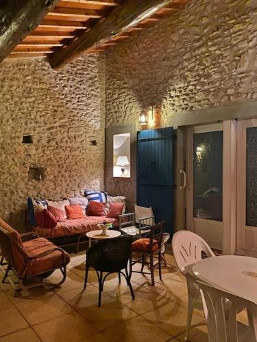 un salon avec un canapé, des tables et des chaises dans l'établissement Maison Pauline, à Saint-André