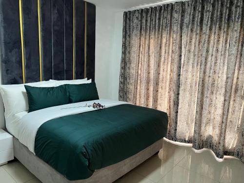 a bedroom with a bed and a large window at Shobalenku Opulent apartments in Mbabane