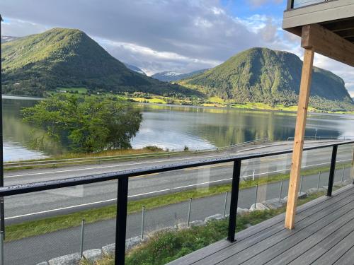 a balcony with a view of a river and mountains at Husslåttene apartments with terrace in Skei 