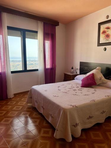 ミハスにあるCasa San Antonioのベッドと大きな窓のある寝室