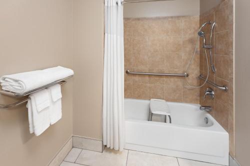 a bathroom with a bath tub and a shower at AmericInn by Wyndham Hudson in Hudson