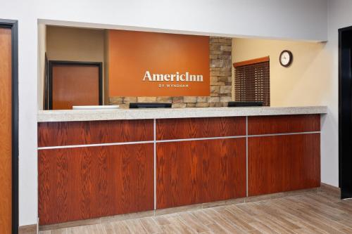 a lobby of an american inn with a reception desk at AmericInn by Wyndham Hudson in Hudson