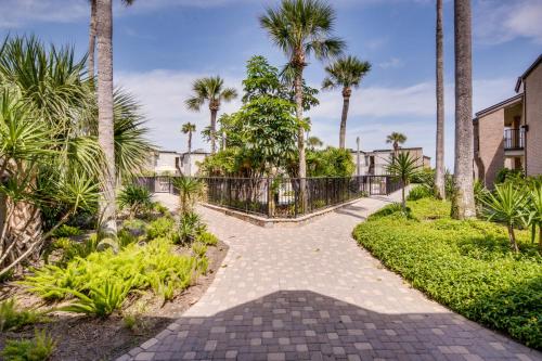 a walkway with palm trees and a fence at Sunchase Beachfront #210 in South Padre Island