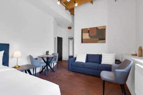a bedroom with a bed and a couch and chairs at The Little Prince Rooms-Old Montreal in Montréal