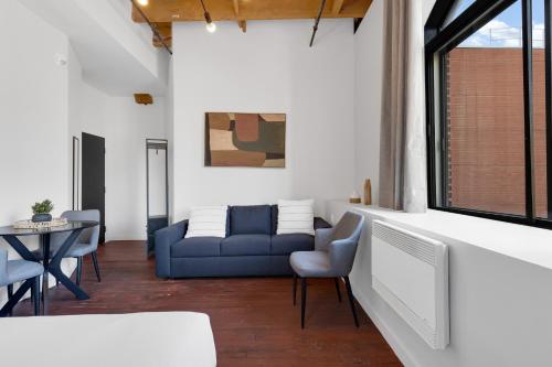 a living room with a blue couch and a table at The Little Prince Rooms-Old Montreal in Montréal