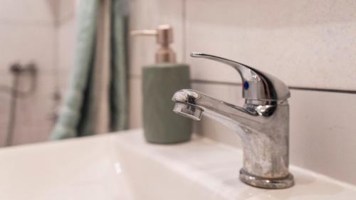 a bathroom sink with a faucet and a mirror at Guest House Time Out in Sarajevo