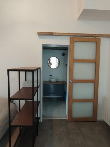 a room with a door and a bathroom with a sink at Maisonnette proche mer in Lannion