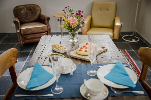 a table with a blue table cloth and a vase of flowers at B&B Art.14 in Morkhoven