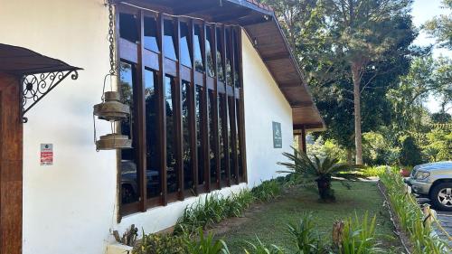 a house with a window and a fence at Hotel Colinas de Petropolis in Petrópolis