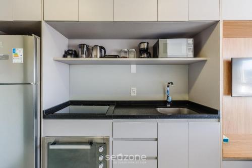a small kitchen with a sink and a refrigerator at Studio Completo ao Lado da PUCRS CON1506 in Porto Alegre