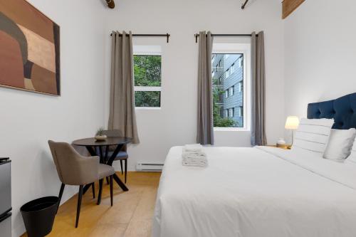 a white bedroom with a bed and a desk at The Little Prince Rooms-Old Montreal in Montréal