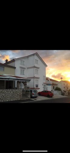 a building with a red car parked in front of it at villa Niki in Crikvenica