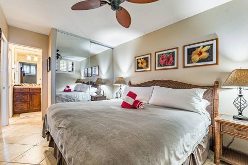 a bedroom with a large bed with a ceiling fan at KS507 Spectacular Oceanfront with Split AC Wailea in Wailea