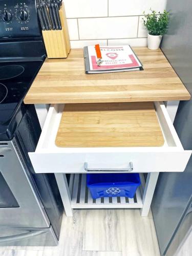 a table in a kitchen with a book on it at Hamilton Chic Retreat - Comfy Beds - Garden - Pool in Hamilton
