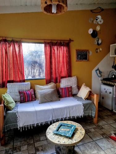 a living room with a bed and a table at Kiritina´s House Homestay in El Calafate
