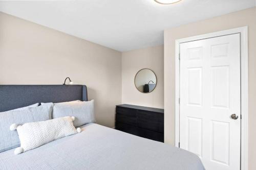 a bedroom with a white bed and a mirror at Nantasket Nest in Hull