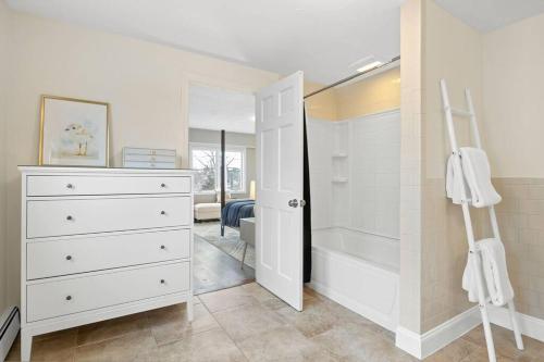 a bathroom with a walk in shower and a white dresser at Nantasket Nest in Hull