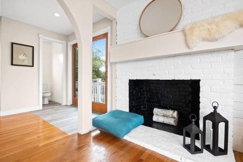 a living room with a fireplace and a blue ottoman at Nantasket Nest in Hull