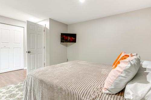 a bedroom with a bed and a white wall at about 2 Mi to Downtown Bright Apt in Lansing! in Lansing