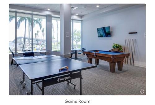Dos mesas de ping pong en una habitación con sala de juegos. en Luxe Penthouse Waterfront Loft, en Fort Myers