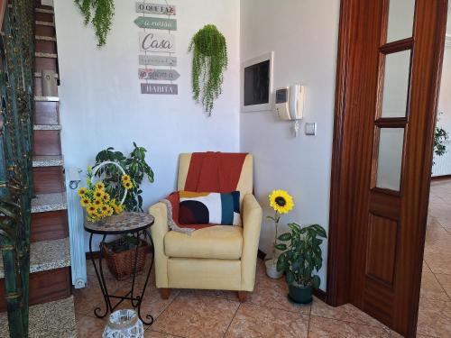 a chair in a room with plants and a table at Ana Paula House in Aveiro
