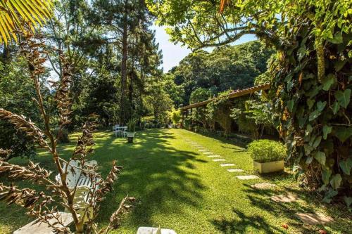 a garden with trees and a green yard at Hotel Colinas de Petropolis in Petrópolis