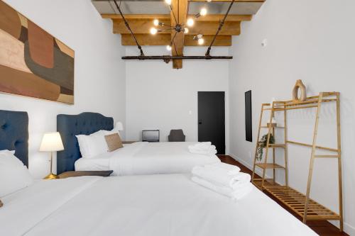 a bedroom with two white beds and a ladder at The Little Prince Rooms-Old Montreal in Montréal