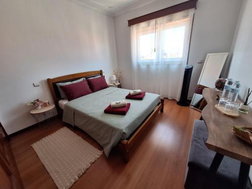 a bedroom with a bed with red pillows on it at Ana Paula House in Aveiro