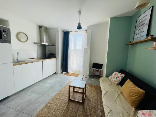 un salon avec un canapé et une table dans l'établissement La Gare - Appartement face à la gare plein, centre, à Lille