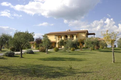 a house in a field with trees in front of it at Agriturismo Buriano in Lubriano