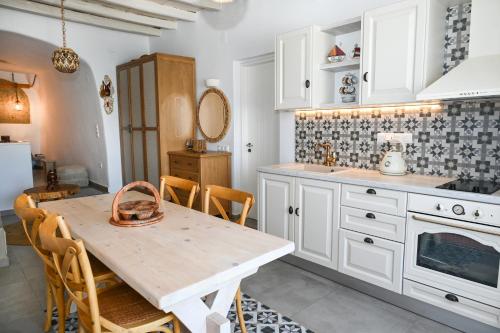 a kitchen with a wooden table with chairs and a counter at Fisherman's Syrma House in Pachaina