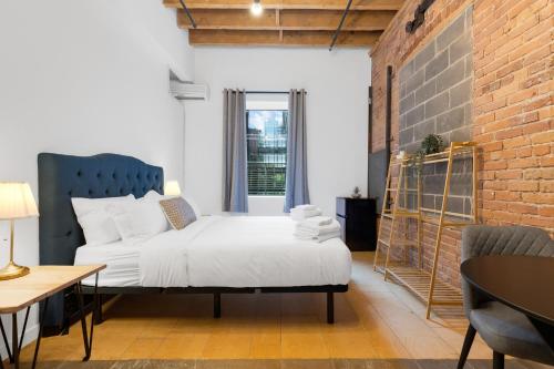 a bedroom with a bed and a brick wall at The Little Prince Rooms-Old Montreal in Montréal