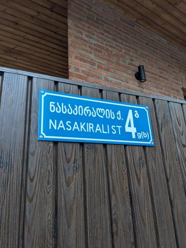 a blue street sign hanging on a wooden fence at Labu Hotel in Tbilisi City