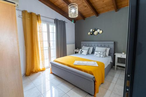 a bedroom with a bed with a yellow blanket at Evelina 5 in Lixouri