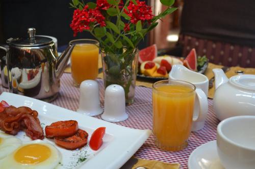 a table with a plate of breakfast food and orange juice at Kongoni Camp in Nanyuki
