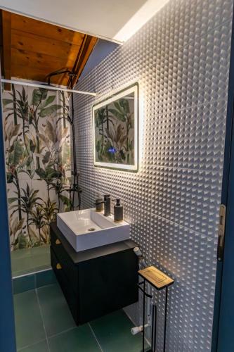 a bathroom with a sink and a tile wall at Evelina 5 in Lixouri