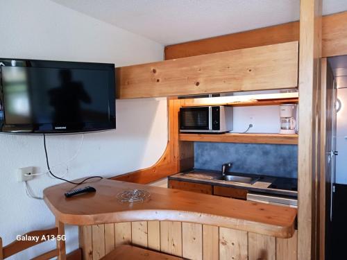 - une cuisine avec une table, une télévision et un évier dans l'établissement Résidence Lauzieres - Studio 5 personnes skis aux pieds et proche des commerces dans le village du Charvet à Arc 1800 MAE-1901, à Arc 1800