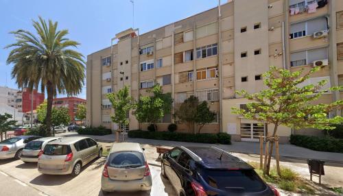 un parking avec des voitures garées devant un bâtiment dans l'établissement Malvarrosa habitación cómoda y sencilla cerca de la playa, à Valence