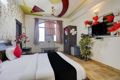 a bedroom with a large white bed in a room at Hotel O Mukut Mahal in Meerut