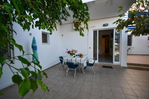 a patio with a table and chairs in front of a building at Long Beach Koutsounari in Ierápetra