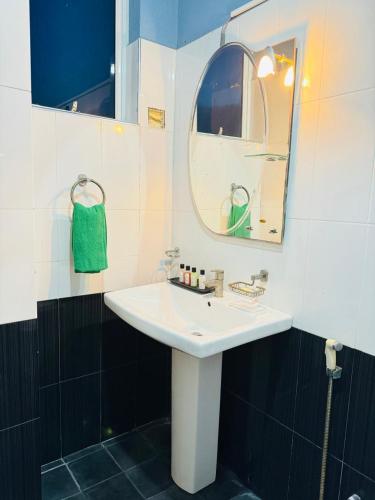 a bathroom with a white sink and a mirror at CITYSCAPE YALA BY 999 HOTEL & RESTAURANT in Tissamaharama