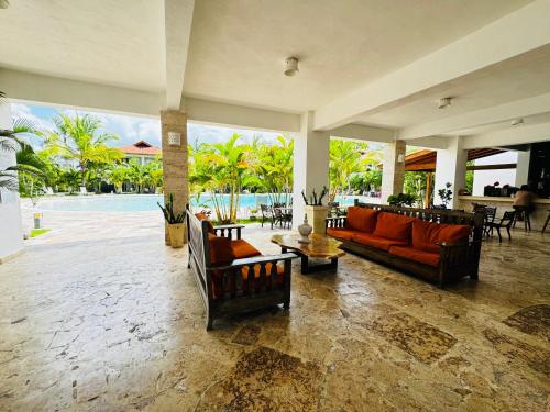 a living room with orange couches and a pool at Vista Bayahibe Paradise in Bayahibe