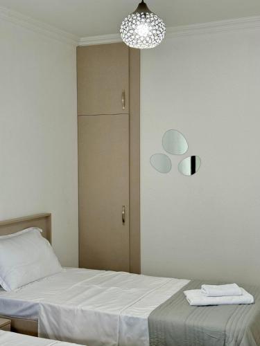 a bedroom with two beds and a chandelier at Sunny Kvareli in Kvareli