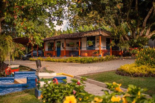 a small house in a garden with flowers in front of it at Hotel Mi Monaco in Pueblo Tapao