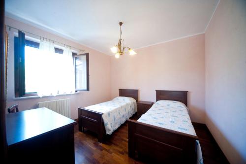 a bedroom with two beds and a window at Agriturismo Buriano in Lubriano