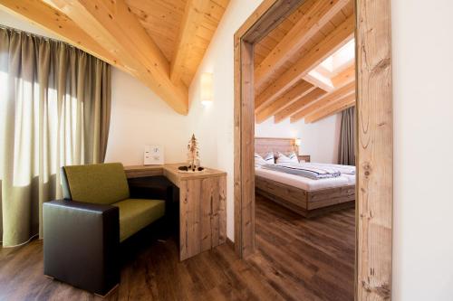 1 dormitorio con 1 cama y 1 silla en Top View - Panorama Apart Sölden, en Sölden