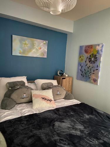 une chambre avec un grand lit avec des oreillers dessus dans l'établissement Le Coquelicot de Luchon, à Luchon