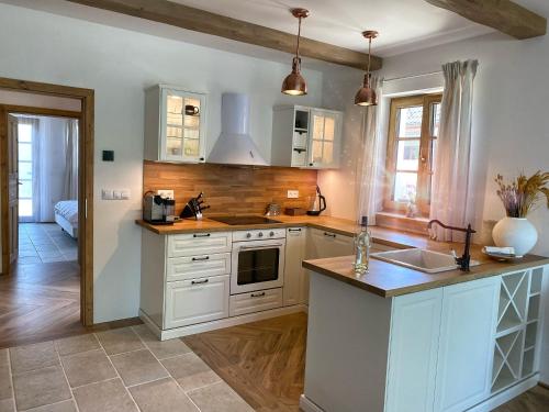 a kitchen with white cabinets and a counter top at Treestudio Apartment in Lipí