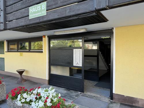 an open door of a building with flowers in front at Ferienwohnung im Zentrum von Bad Aussee in Bad Aussee