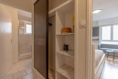 une chambre avec une porte coulissante en verre menant au salon dans l'établissement Studio Strasbourg proche gare, à Strasbourg